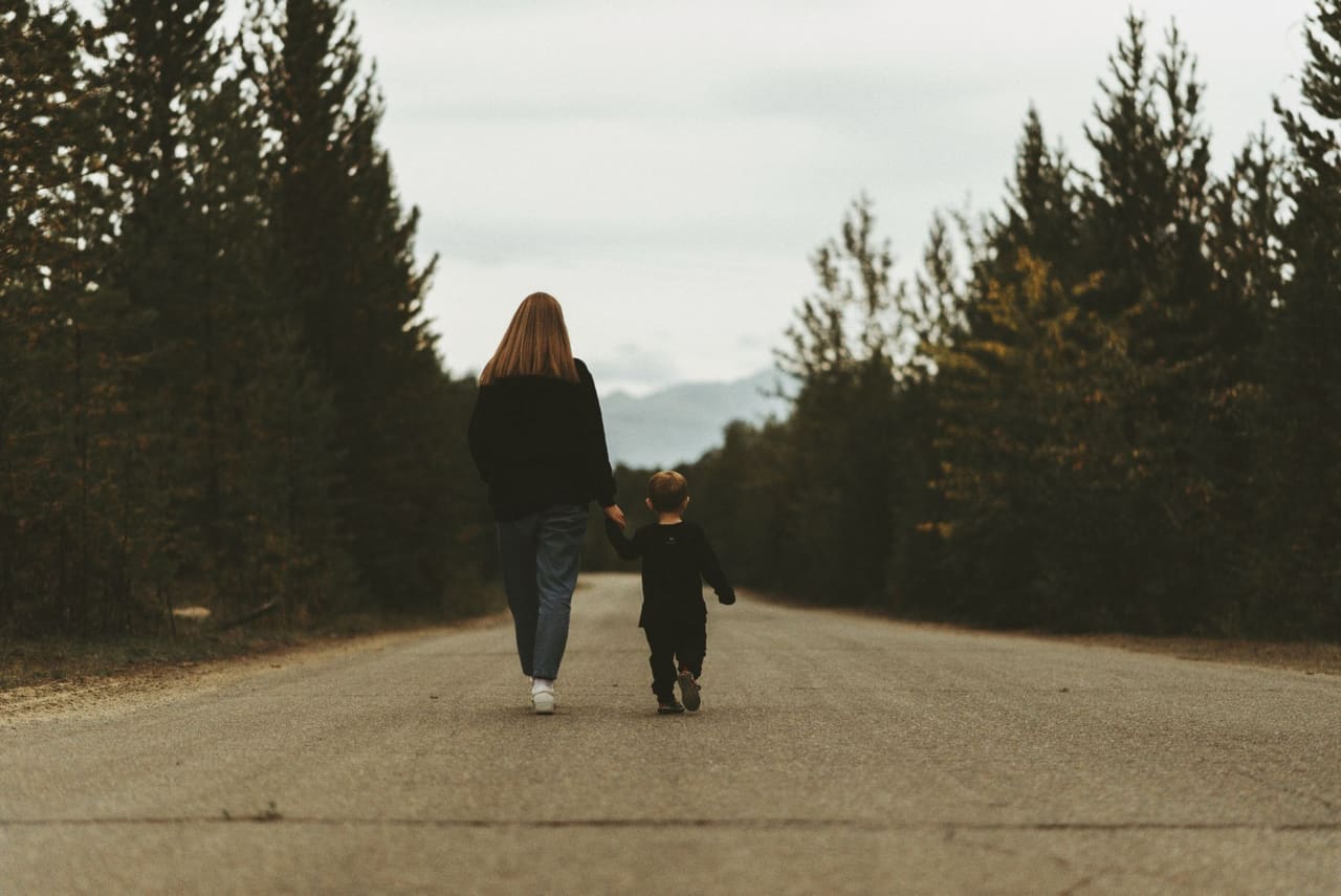 Parent holding a child's hand while walking together